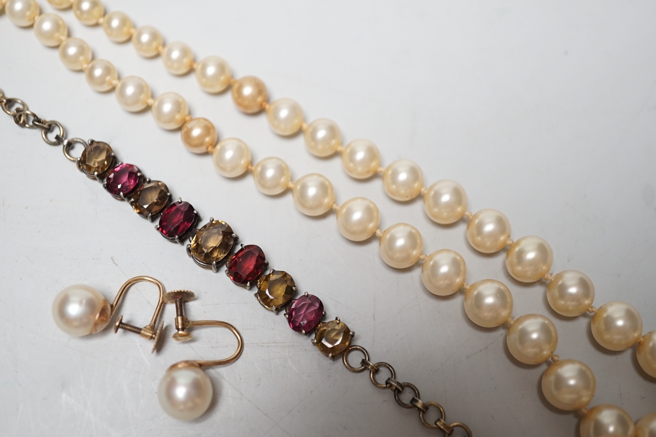 A gilt metal and coloured paste set bracelet, a pair of 9ct and cultured pearl set ear clips and a simulated pearl necklace, with 9ct clasp.